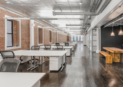 Enterprise office space with rows of desks and large amount of bright space.