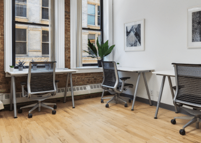 Private office space with two desks, multiple chairs and amenities visible.