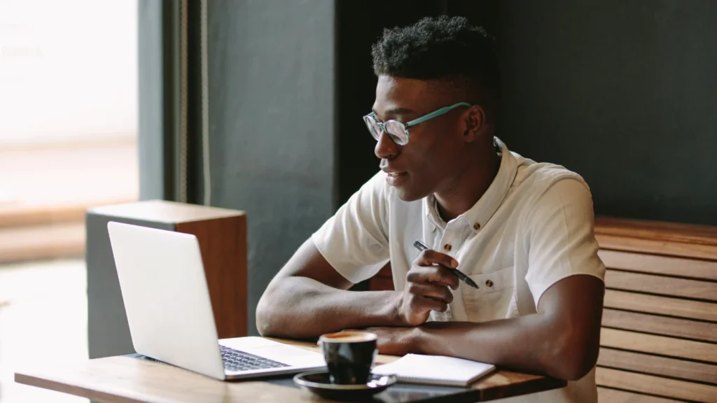 Person working on a laptop in a coffee shop.