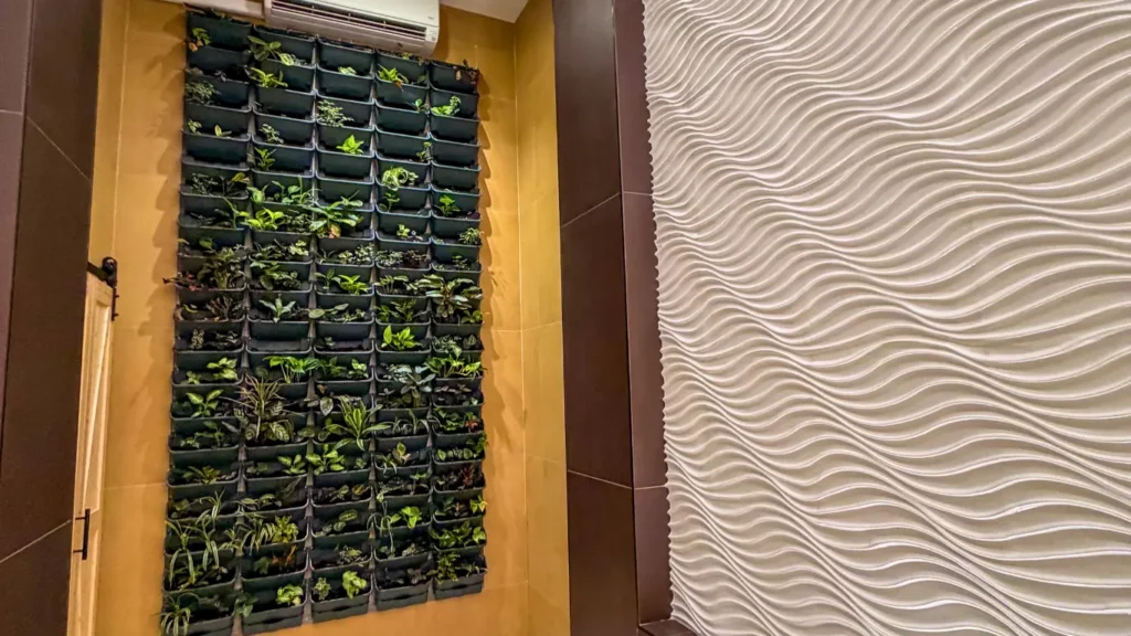 Vertical indoor garden and textured wall bringing biophilic design into a modern coworking space hallway.