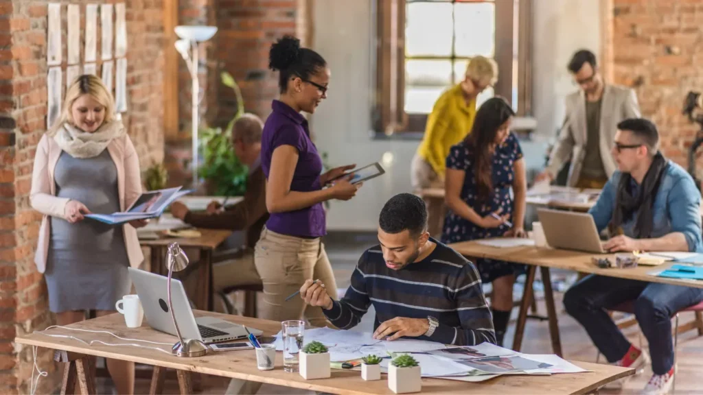 Busy coworking space with people collaborating at shared desks.