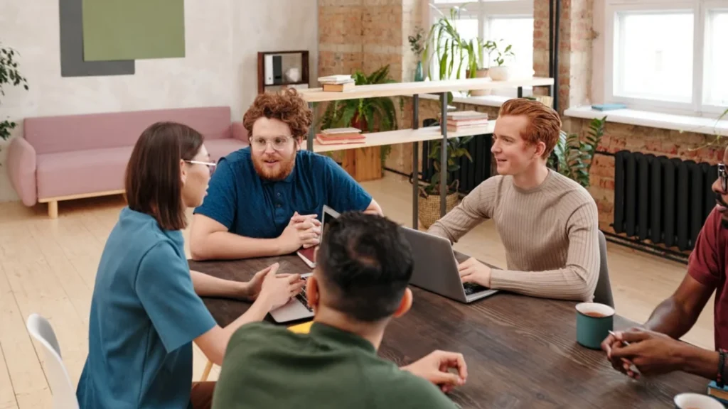 Team meeting around a table in a bright office.