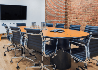 Large meeting room with prominent hardwood table and areas for seating around.