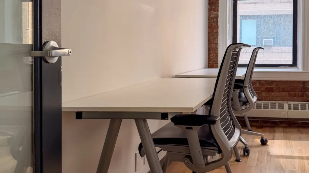 Small private office in Chelsea with two desks and ergonomic chairs by a window