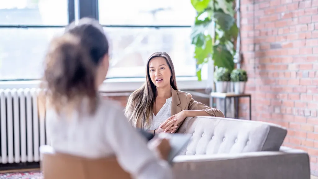 Woman talking with therapist in a bright counseling room.