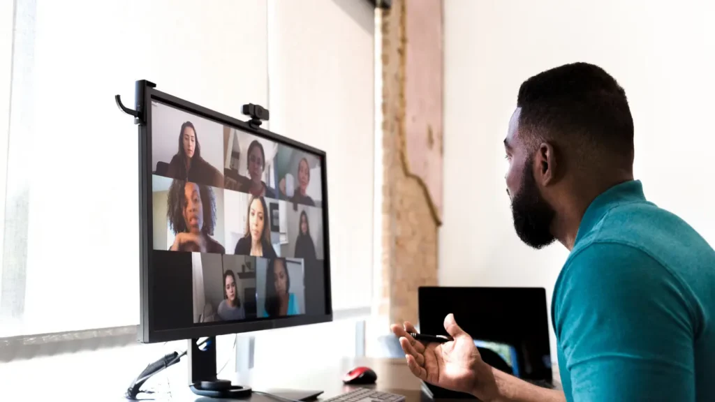 Professional leading a virtual meeting with team members on screen.